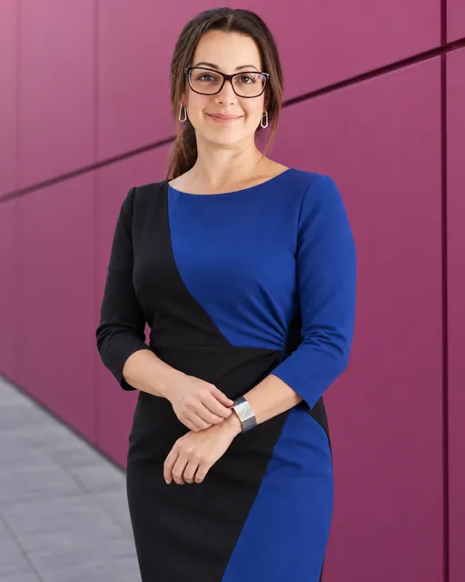 Michelle Newman, Managing Director of CAQA Groups, smiles while wearing a blue and black dress.